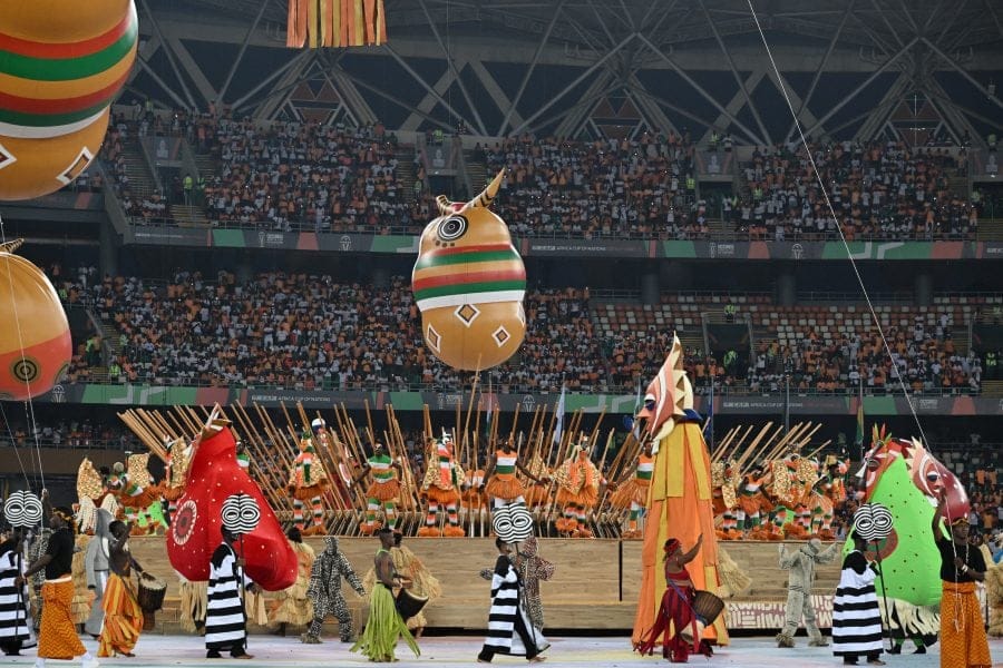 Spectacle vivant CAN 2024 avec danseurs en costumes et ballons géants inspirés de la culture ivoirienne