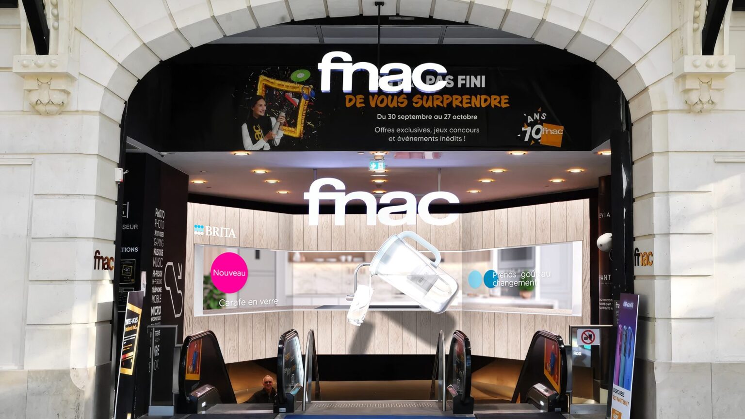 Façade de la FNAC Champs-Élysées affichant une animation 3D BRITA avec effet anamorphique de carafe en verre géante.