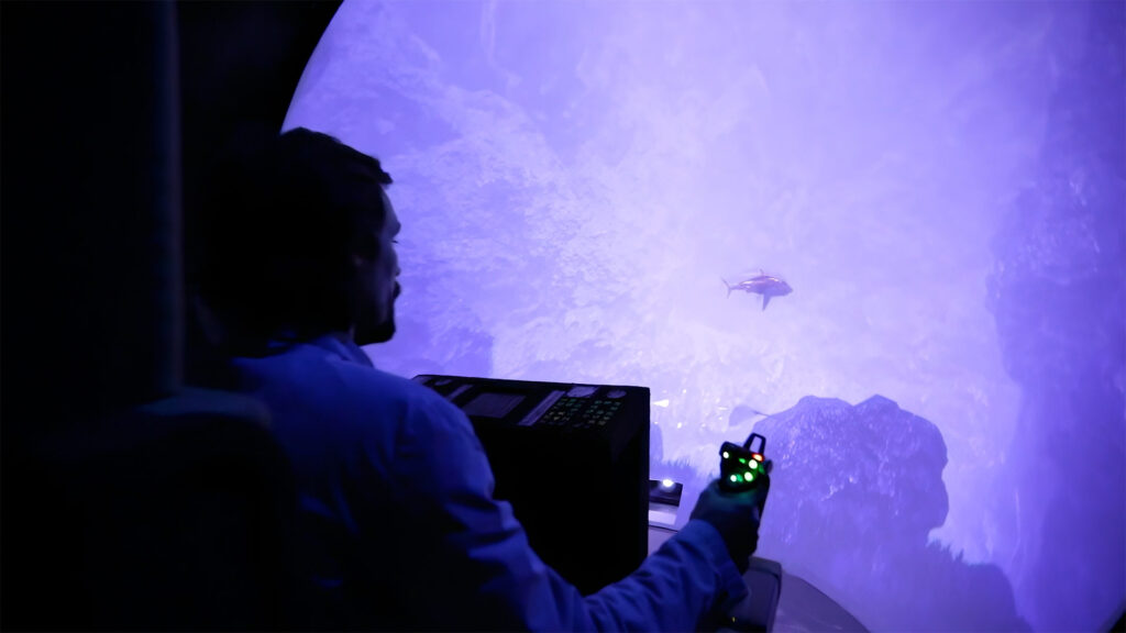 Expérience interactive Panerai à Shanghai avec simulateur de pilotage face à une projection 3D d’environnement marin.