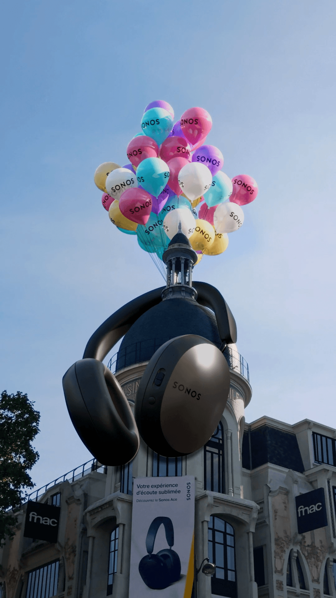 Casque Sonos géant suspendu à la coupole de la Fnac Paris, soulevé par des ballons 3D aux couleurs Sonos.