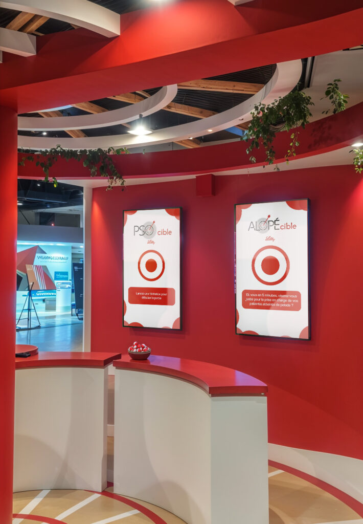 Zoom sur le cœur de l’interaction du stand Lilly : deux écrans verticaux affichant un quiz médical en temps réel. Grâce à un capteur LiDAR intégré, les visiteurs pouvaient répondre aux questions en lançant une balle physique sur la réponse de leur choix, déclenchant une détection précise du point d’impact. Ce système, imaginé par Face X, gamifie la pédagogie scientifique à travers une interface tangible et instantanément engageante pour les professionnels de santé.